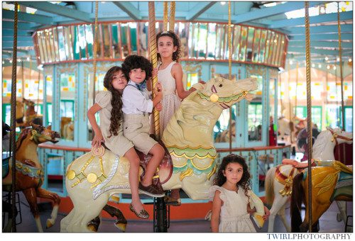 Four young siblings stand on a horse at the carousel gardens at City Park New Orleans.