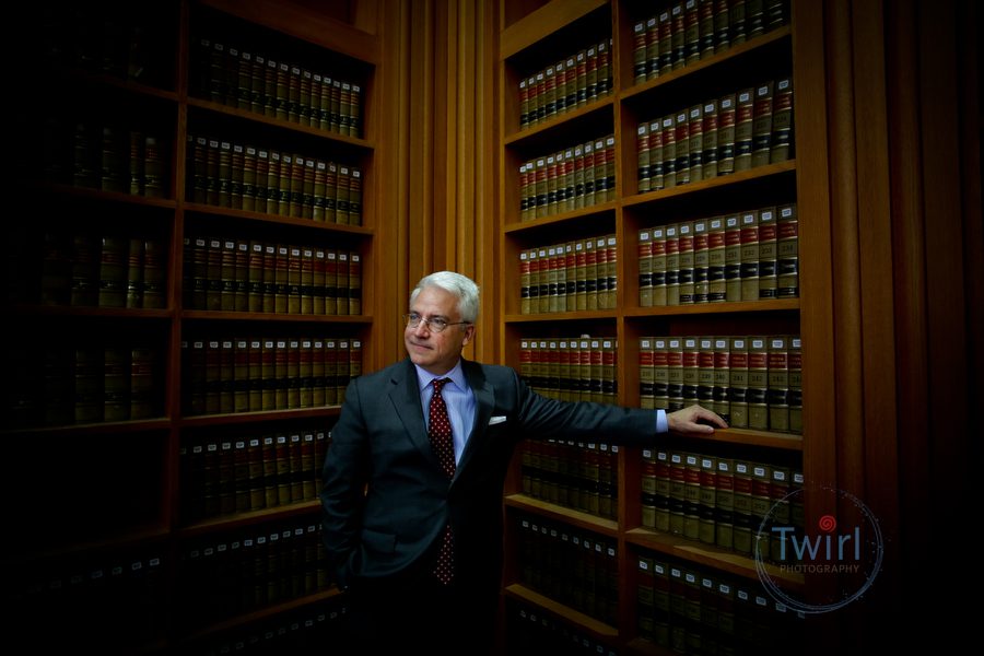 A man in the law library posing for professional portrait at Tulane Law School.