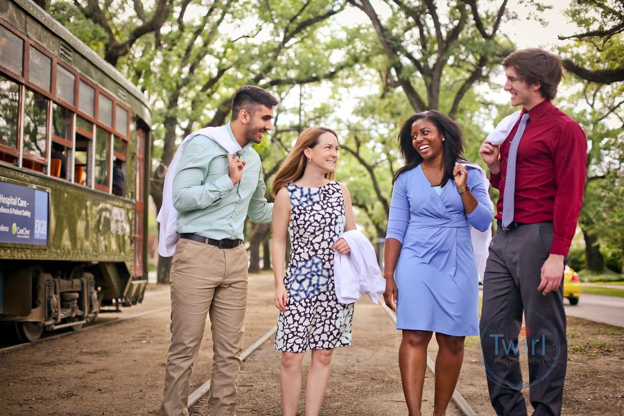 Medical students walk along St. Charles Ave. with a street car going by for a professional portrait and brand photography for Tulane University in New Orleans.