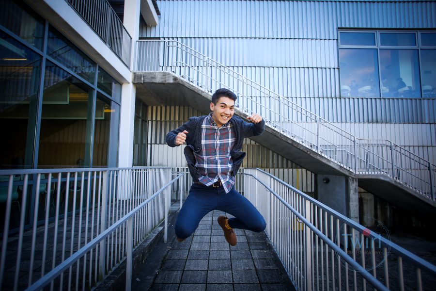 A student at Tulane University jumping in front of a building.