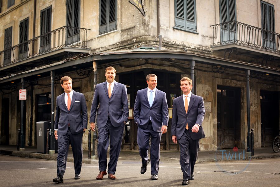 Four men in the financial banking business walking along the French Quarter street for a professional branding photography session in New Orleans.