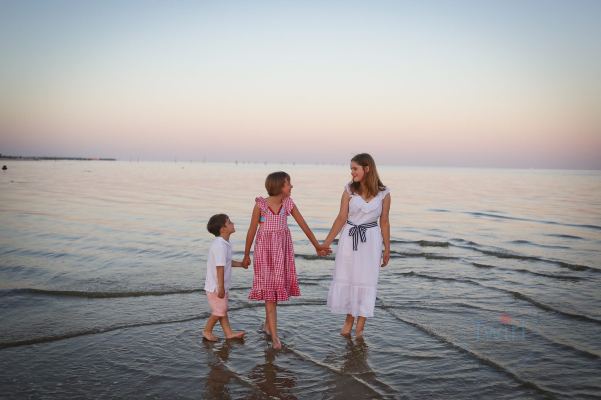 Three kids on the beach at sunset in Bay St. Louis