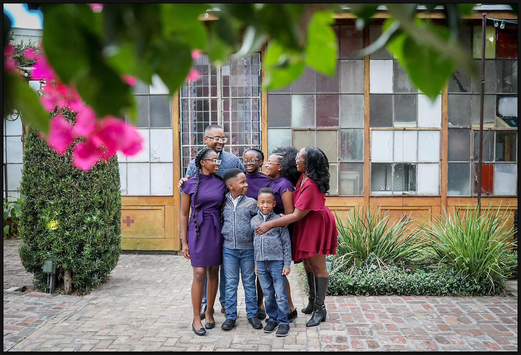 A family gathered together hugging in front of a brightly covered building in New Orleans.