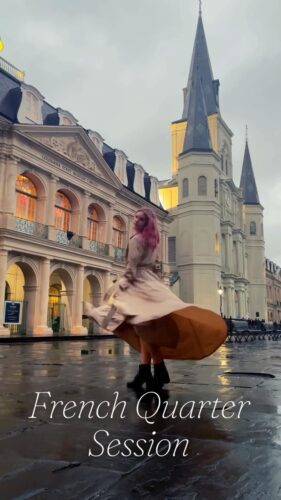 a woman in a dress in front of a building