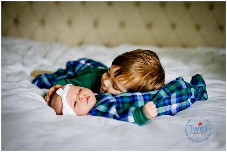 A brother cuddling with his newborn sister in his New Orleans home for pictures.