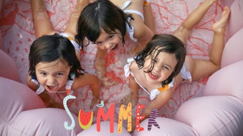 Triplet girls in a small pool giggling for their family portrait in New Orleans