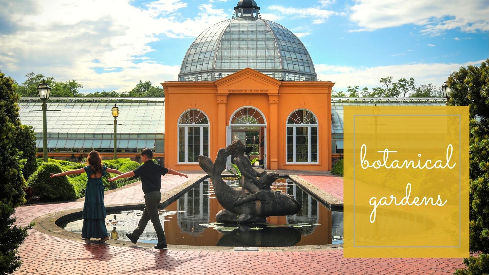 Two kids walking along the rim of a fountain at the New Orleans Botanical Gardens for family photos with Twirl Photography.