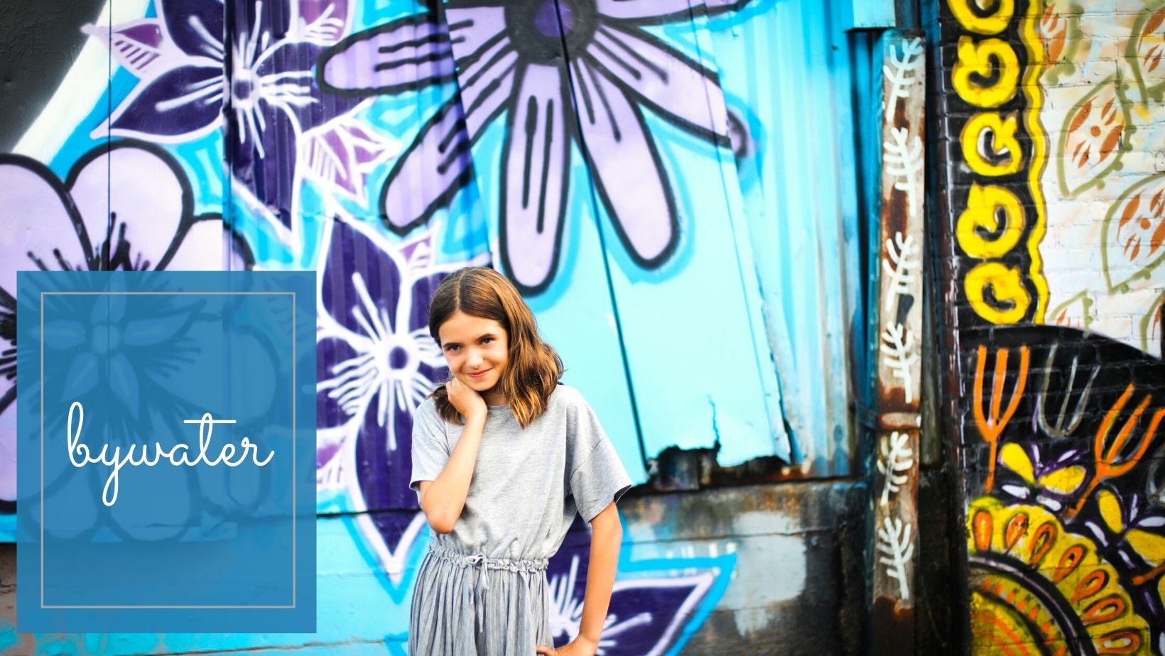 A tween girl in front of colorful graffiti in the Bywater neighborhood for a location guide story on the Best Spots in New Orleans for Family Photos by Twirl Photography.