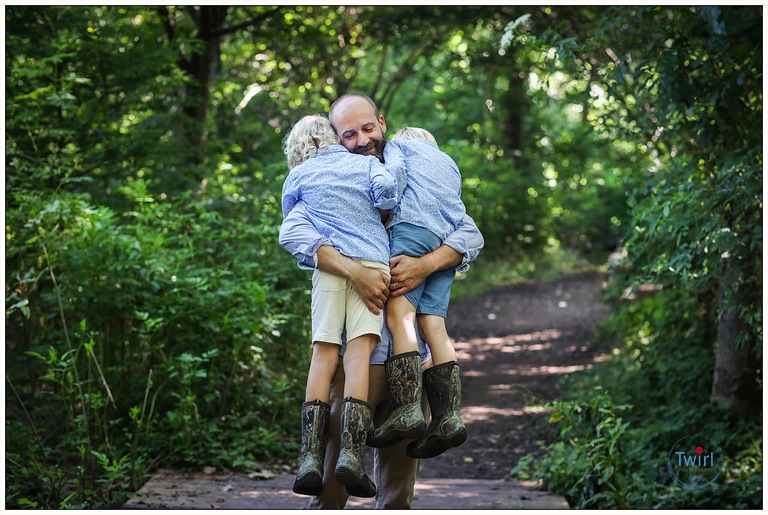 A dad hugging his two sons at Couturie Forest in New Orleans for photos.