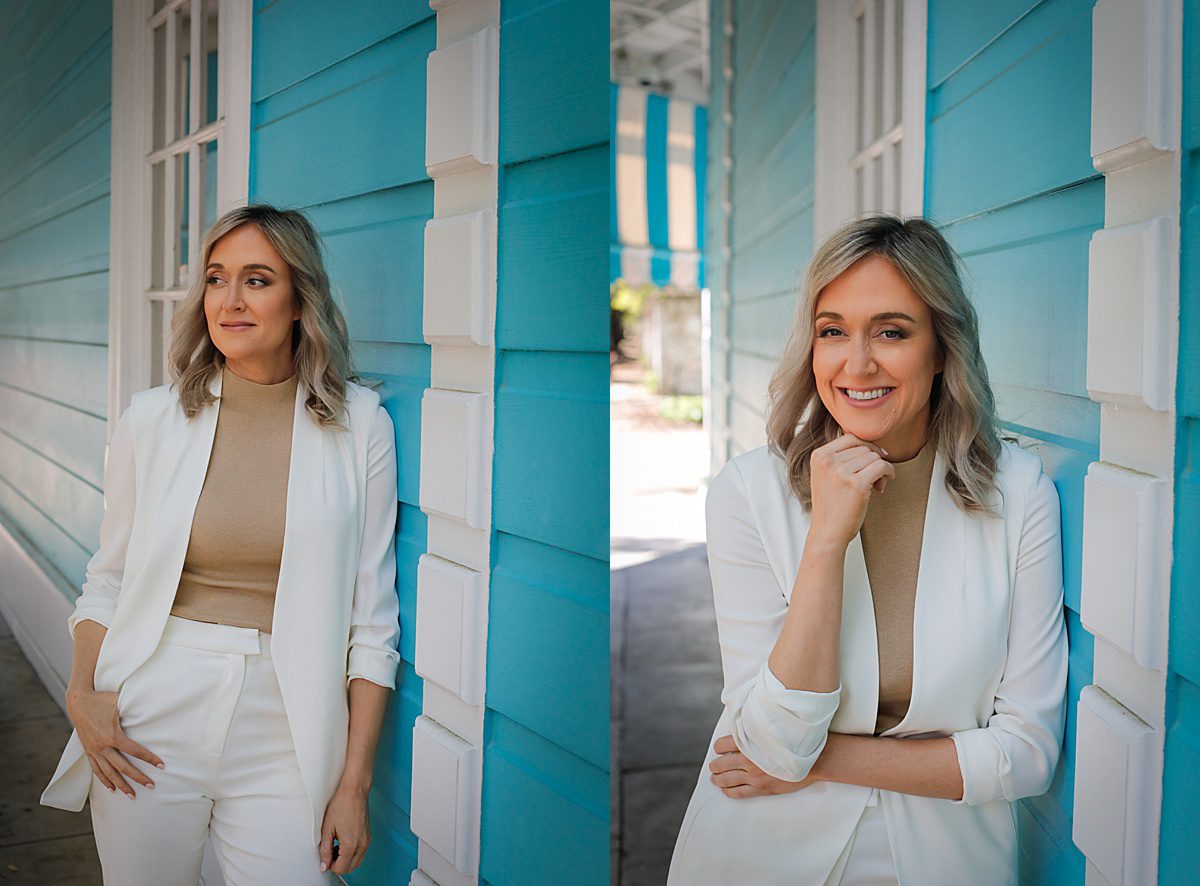 A woman wearing a white suit posing for pictures in front of a blue wall in New Orleans.