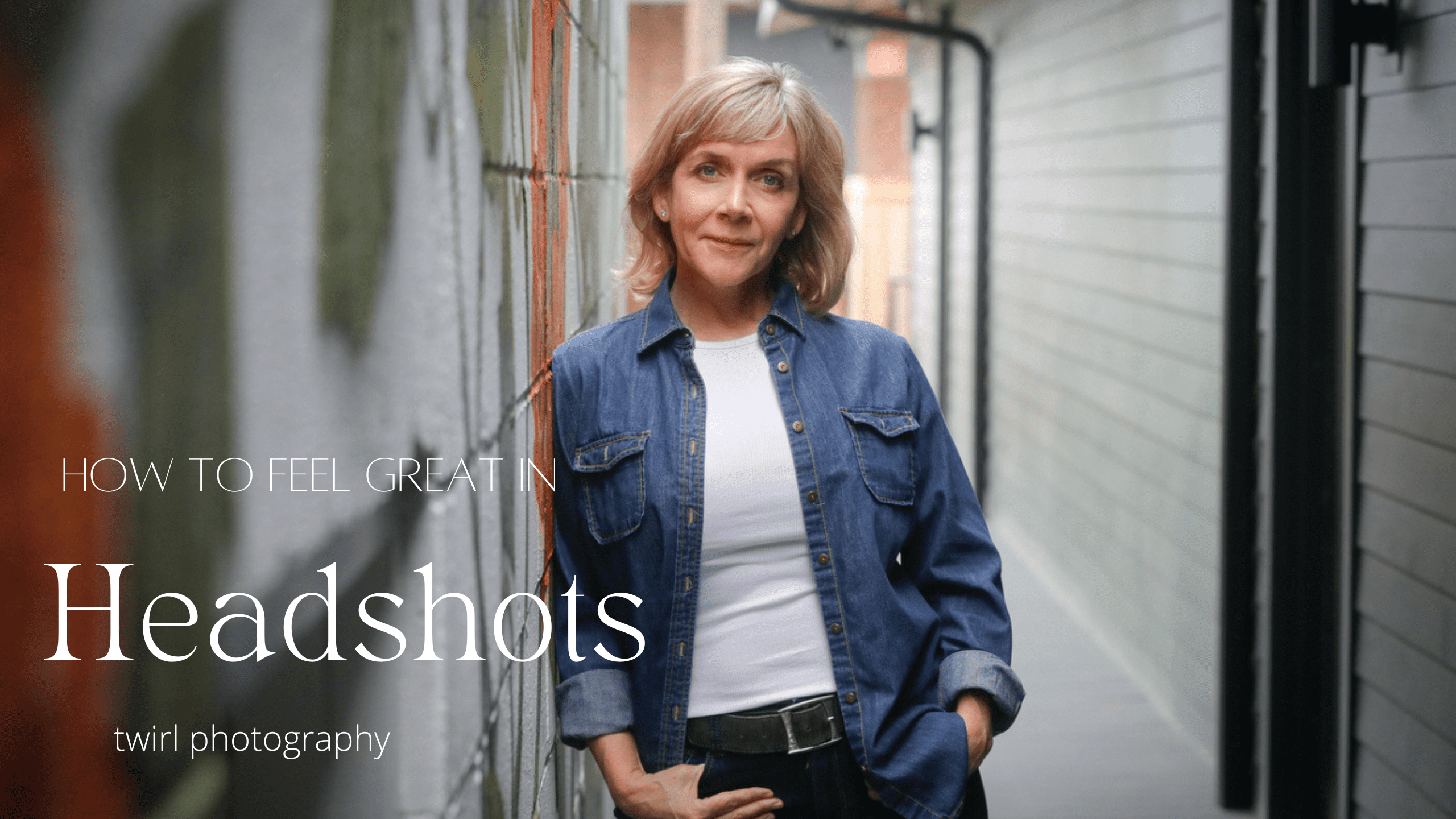 A professional woman wearing a blue top and jeans leaning against a place of business in New Orleans for a headshot photo. 