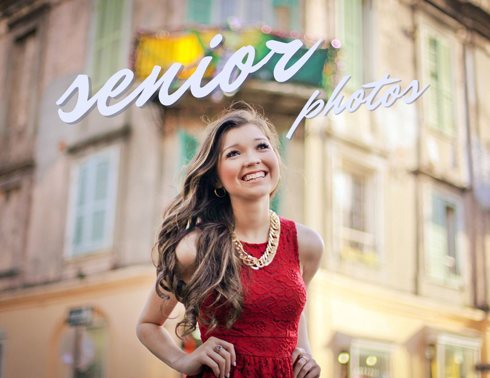 A high school senior girl in a red dress smiling as she twirls in the French Quarter for a story about the perfect outfit for senior portraits.