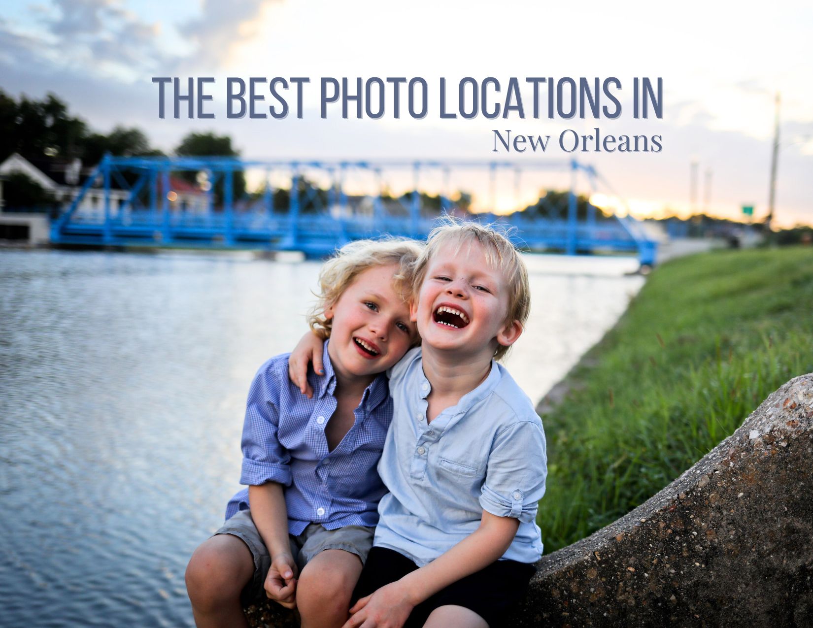 Two young brothers with their arms around each other sitting on the banks of the bayou laughing. Photo for a story about the best photo locations in New Orleans for family photos.