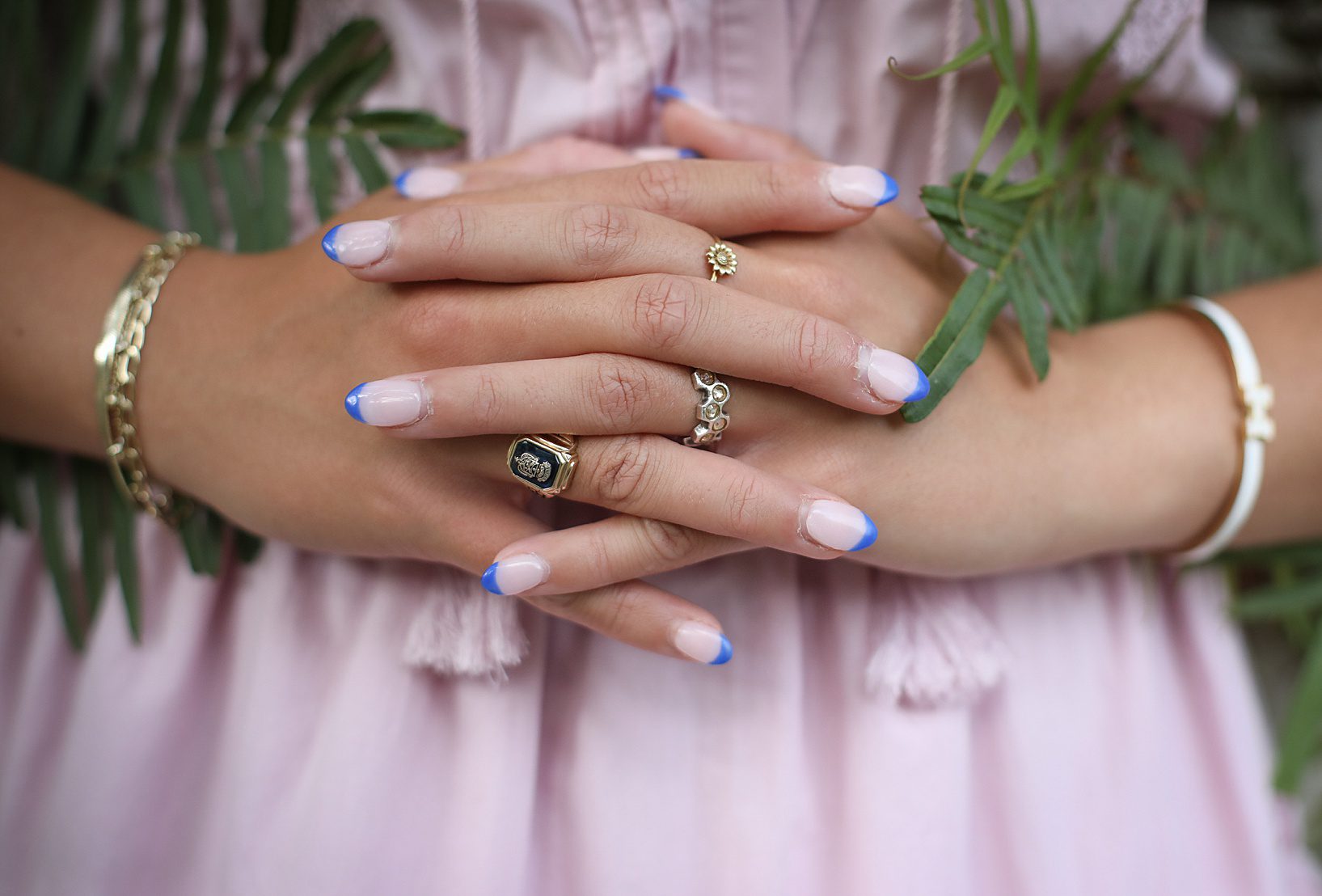 a close up of hands with blue painted nails