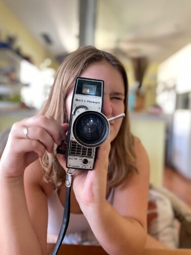 A girl holding a vintage camera.