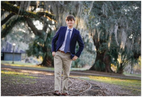 A senior graduate boy walking along the railroad tracks in City Park in New Orleans.