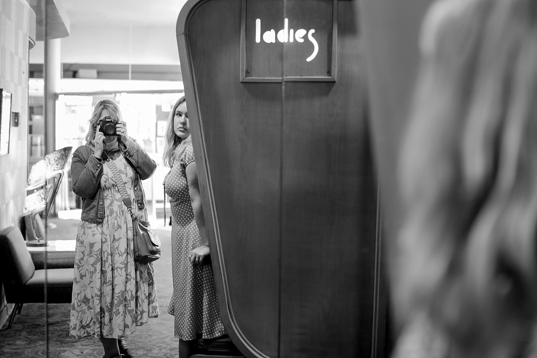 Two women reflected in a mirror.