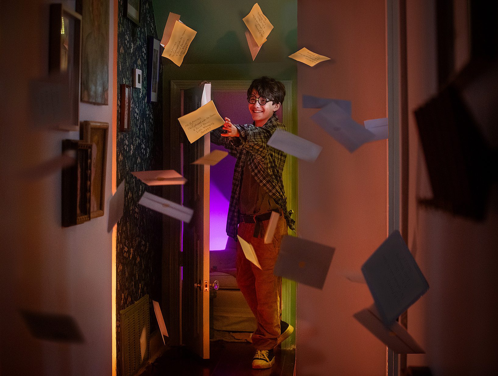 A boy dressed as Harry Potter catching flying letters.