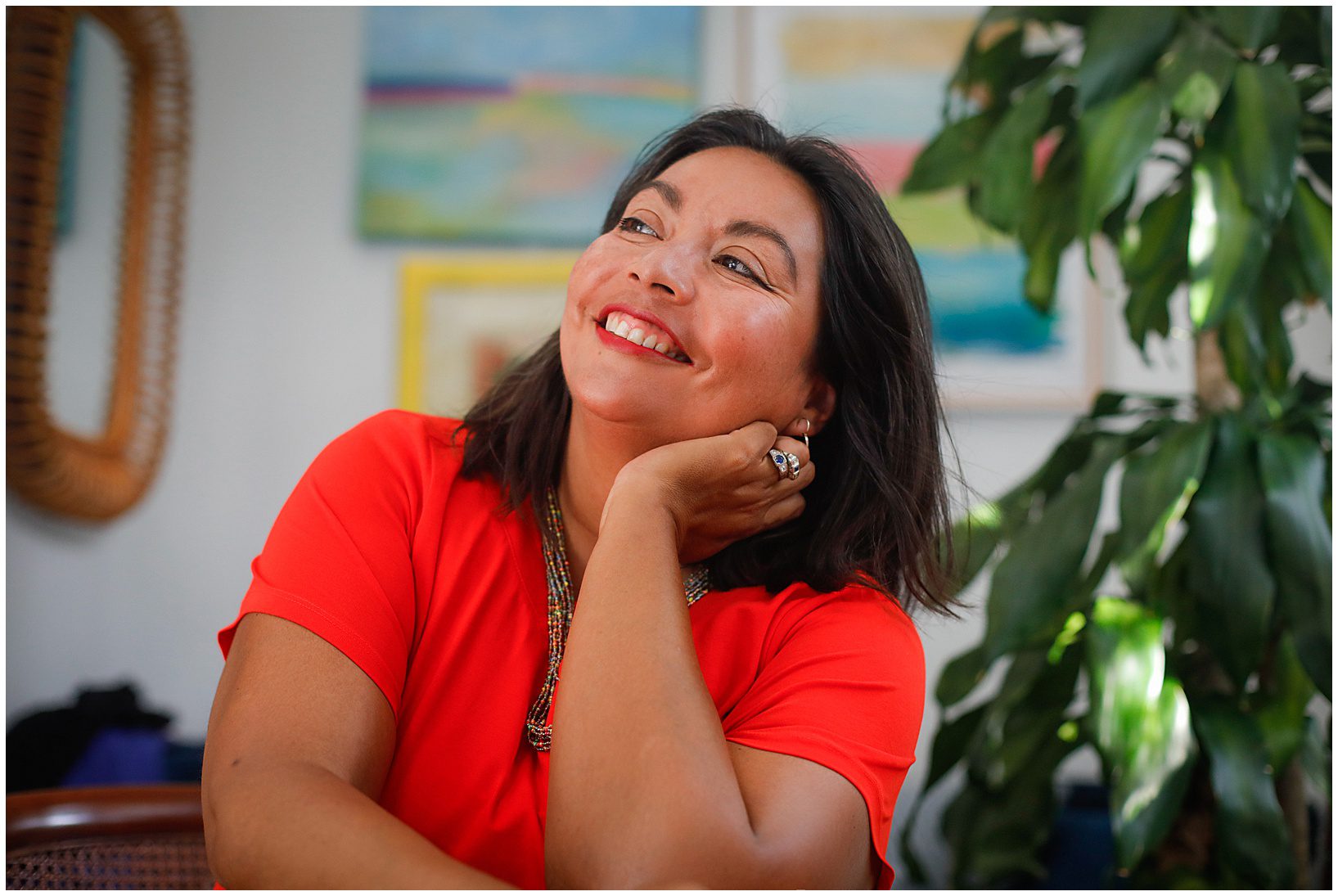A woman wearing a red shirt smiling.