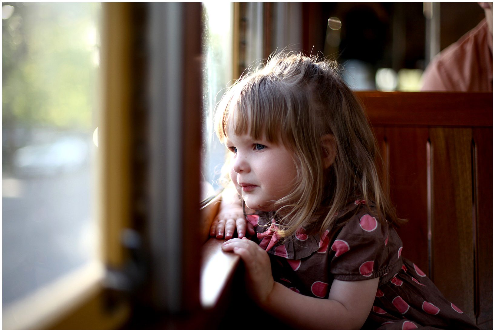 A little girl looking out the window as she rides a streetcar in New Orleans.