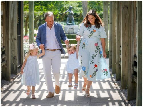 A family walking in a garden wearing spring outfits for photos.