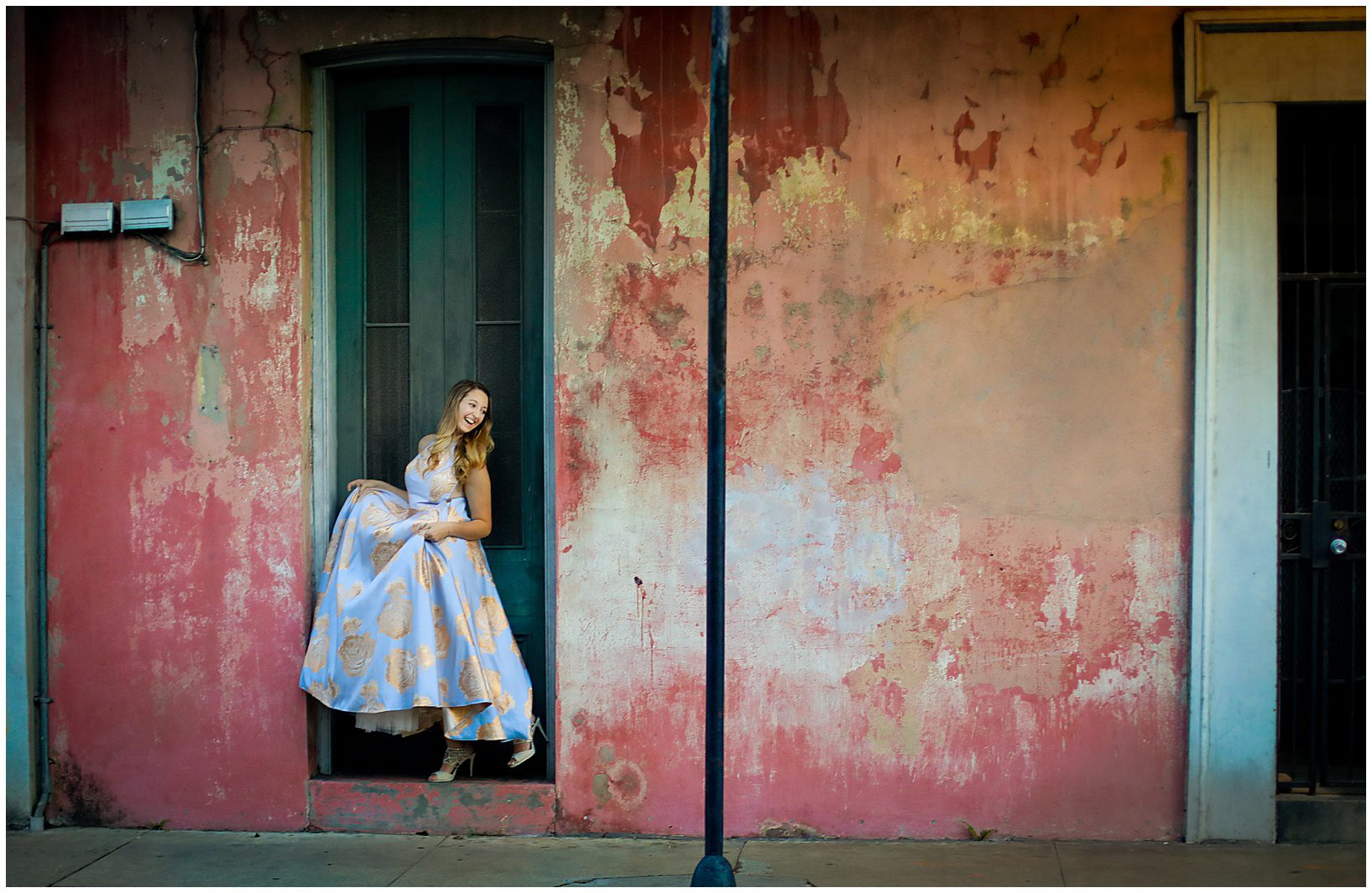A senior high school graduate in a big dress posing for senior photos in the French Qaurter.