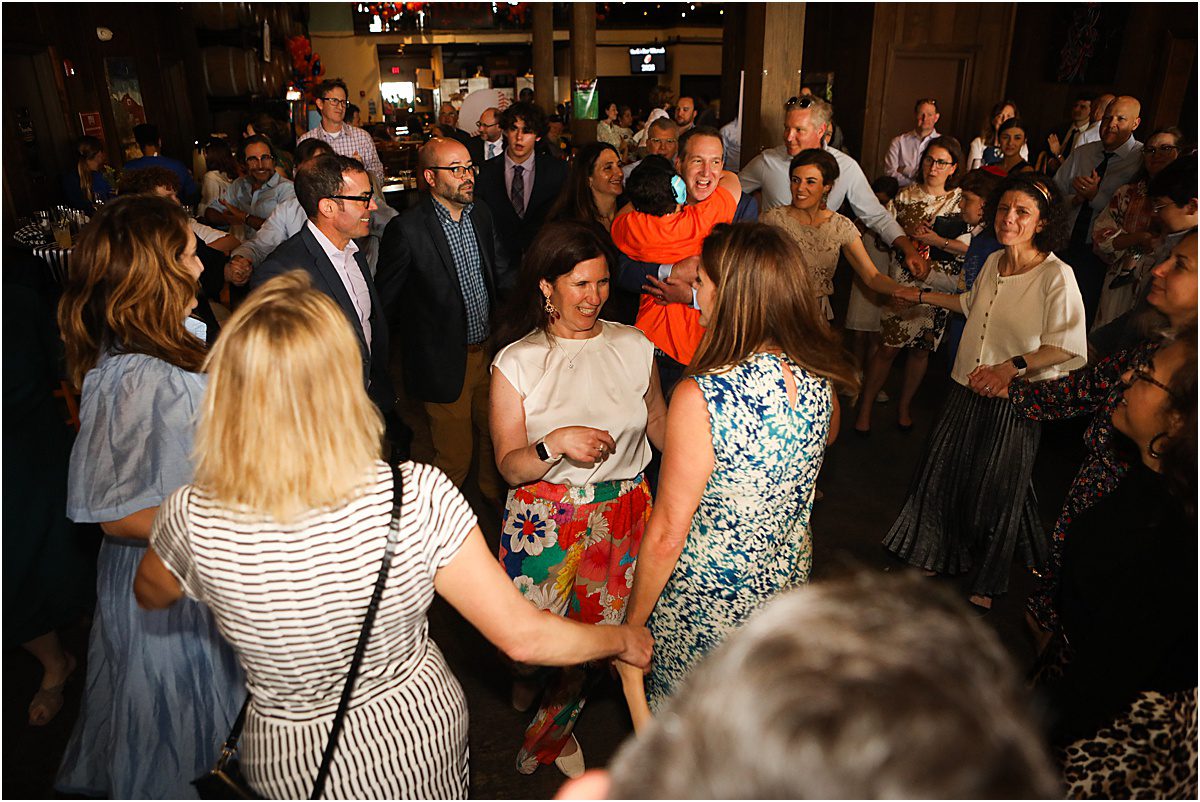 Family and friends dance in a circle during a bar mitzvah.