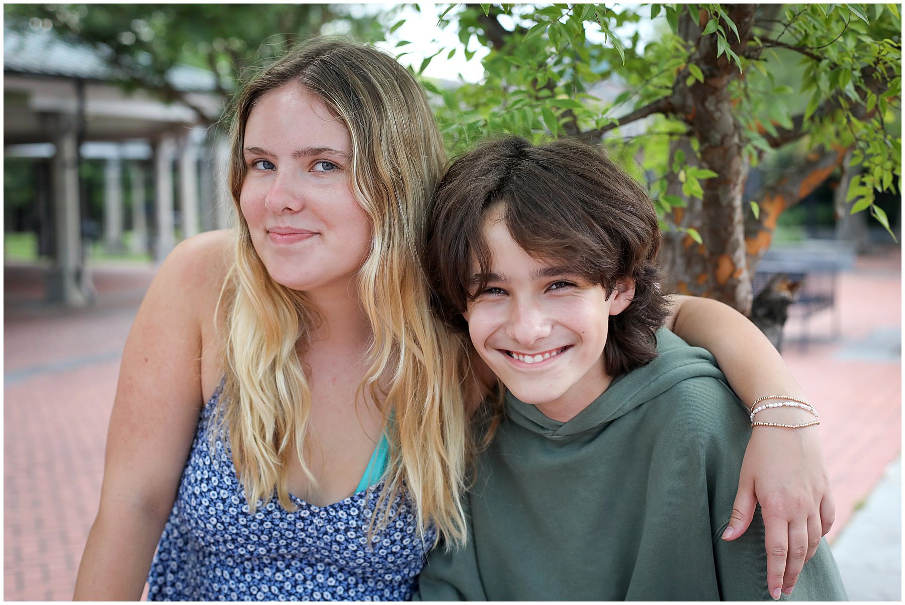 A big sister and younger brother posing for a photo
