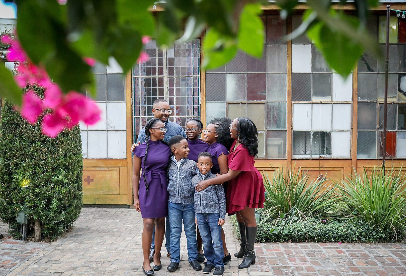 A family of 7 laughs and hugs each other during a photo session.